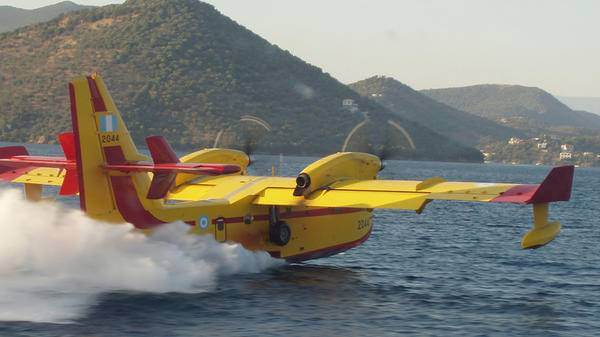 Yellow fire support plane flying on top of sea
