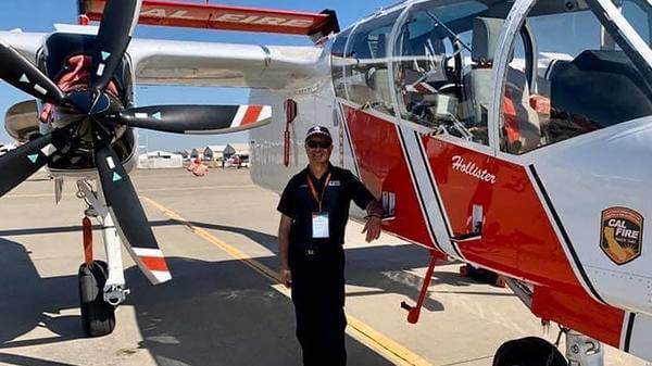 John Katakouzinous standing next to helicopter