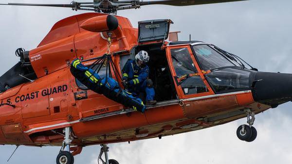 Body being hoisted out of coast guard helicopter