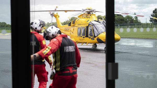 Paramedics walking towards parked helicopter