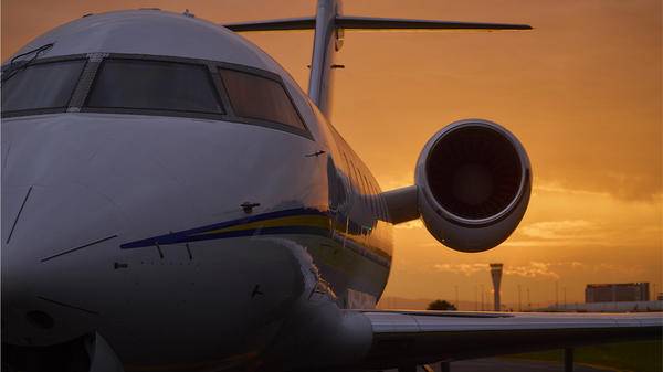 Plane parked in front of sunset