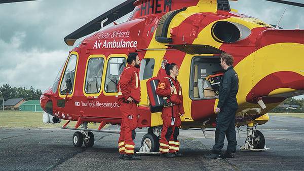 Paramedics talking next to helicopter