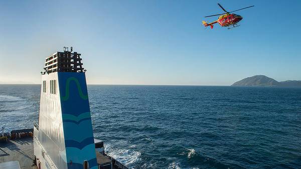 Helicopter flying next to ship
