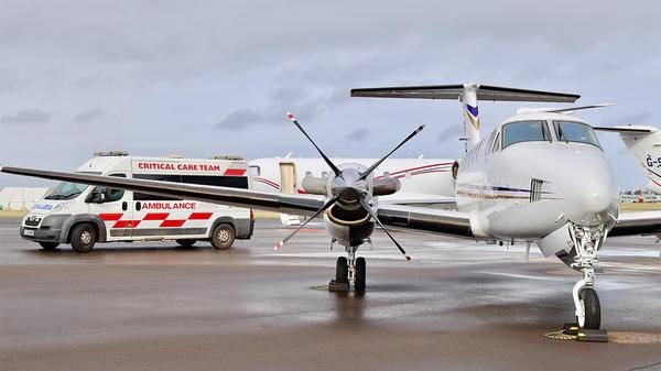 Plane parked on runway next to van