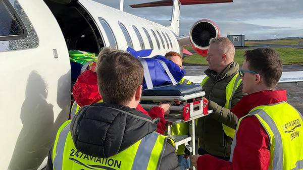Patient being loaded onto plane