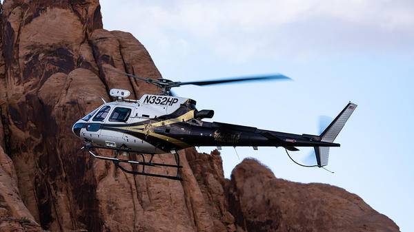Helicopter flying by mountain