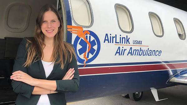 Woman posing next to air ambulance plane