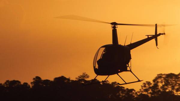 helicopter flying during sunset