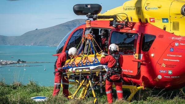 Rescue workers moving patient into helicopter