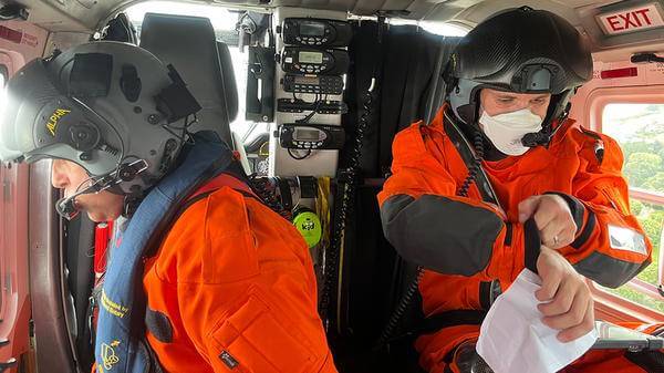 Rescue workers looking out of helicopter