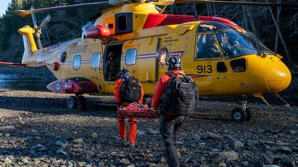 Rescue workers carrying patient to helicopter
