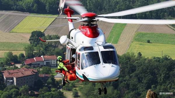 Helicopter mid-flight with rescuer hoisting out