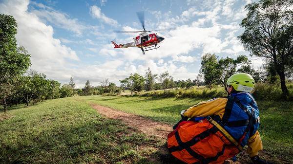 Helicopter landing with rescue personnel watching