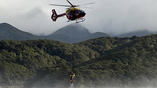 Rescue workers hoisted of water out of helicopter 