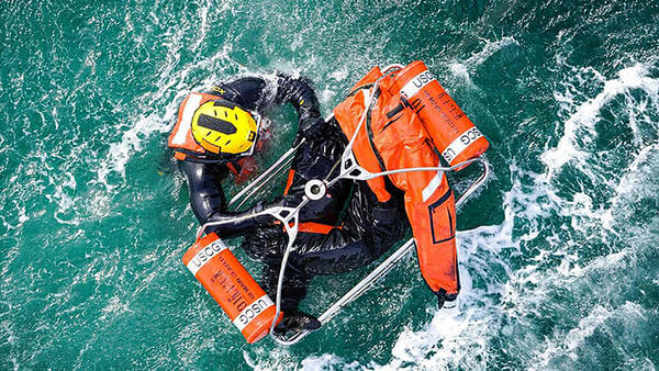 Coast guard rescuer in sea with equipment