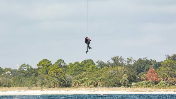Divers being hoisted into sea