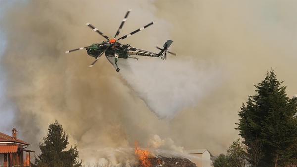 Helicopter dropping fire retardant over town