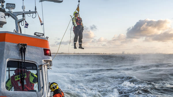 Coast guard hoisted above sea