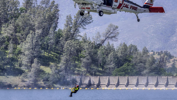 Firefighter hoisted just above water