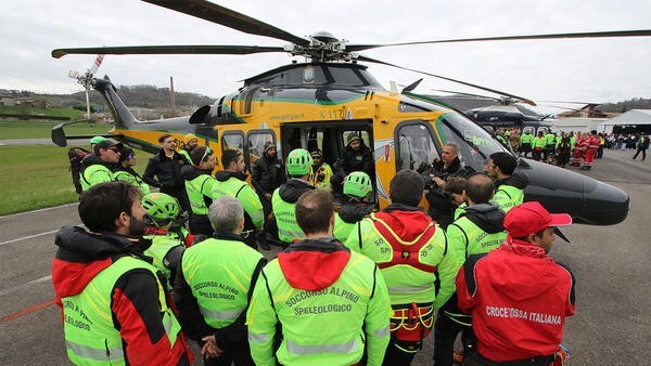 Helicopter parked with workers outside it
