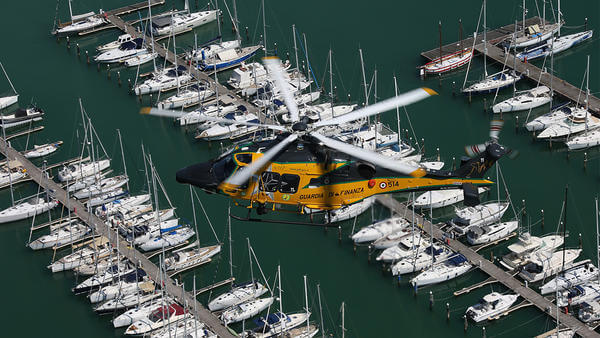 Yellow helicopter flying above harbour