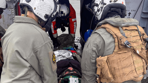 SAR workers putting patient on helicopter