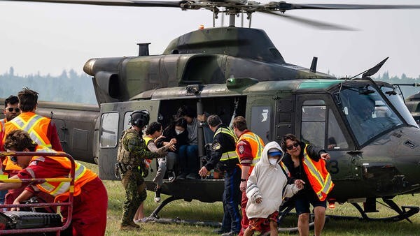People being escorted off of helicopter