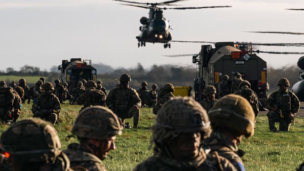 Helicopter landing with military personnel around