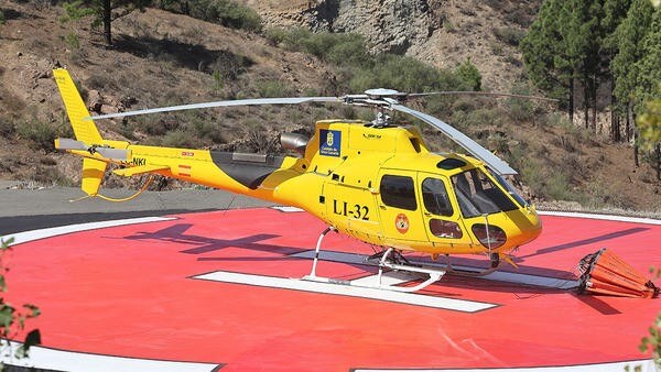 Yellow helicopter parked on landing spot