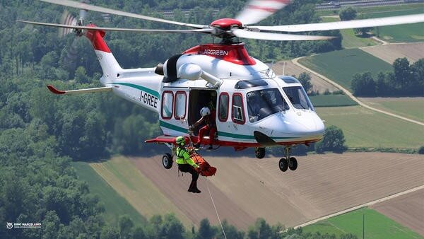 Helicopter mid-flight with rescuer hoisted out